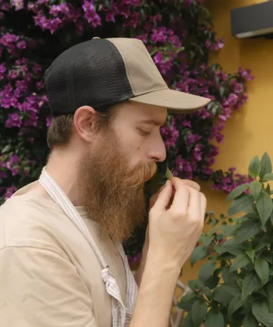 Iñaki oliendo hojas recogidas en el jardín