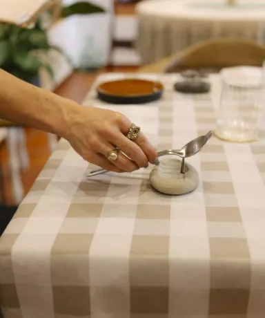 La mano de Lola colocando una cuchara sobre la mesa