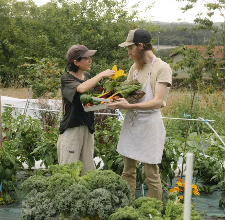 Lola e Iñaki en la huerta, observando productos recién recogidos de la huerta